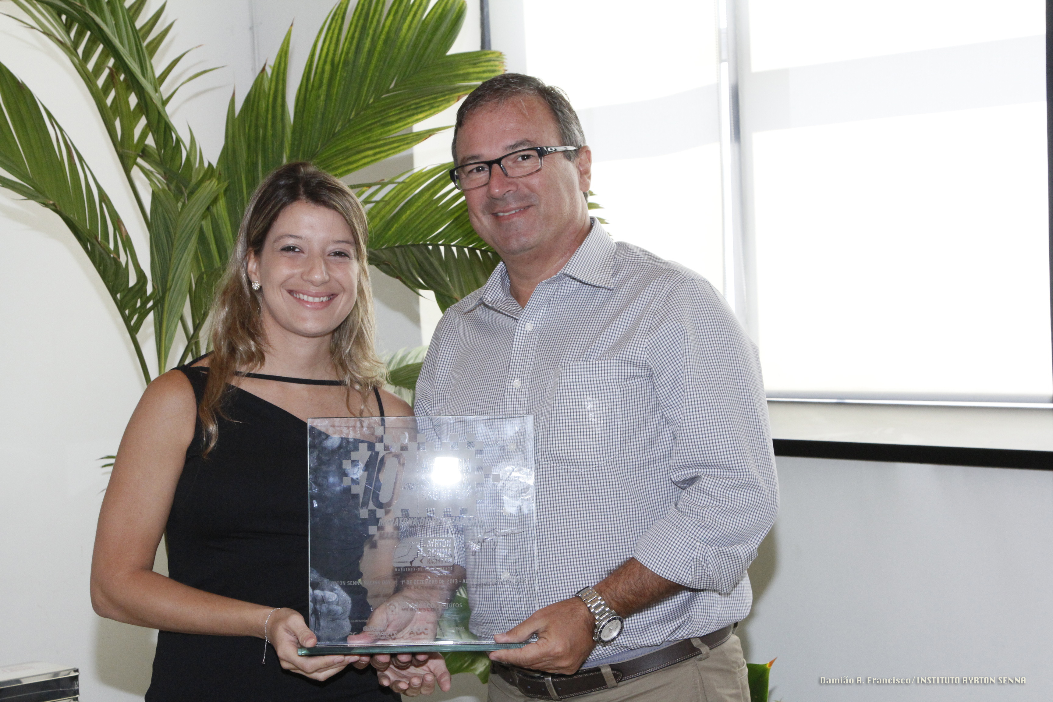 Paola n. Santilli, do Instituto Ayrton Senna, entrega o prêmio para João Mahalik, gerente do Autódromo de Interlagos. Foto: Damião A. Francisco/ Instituto Ayrton Senna.